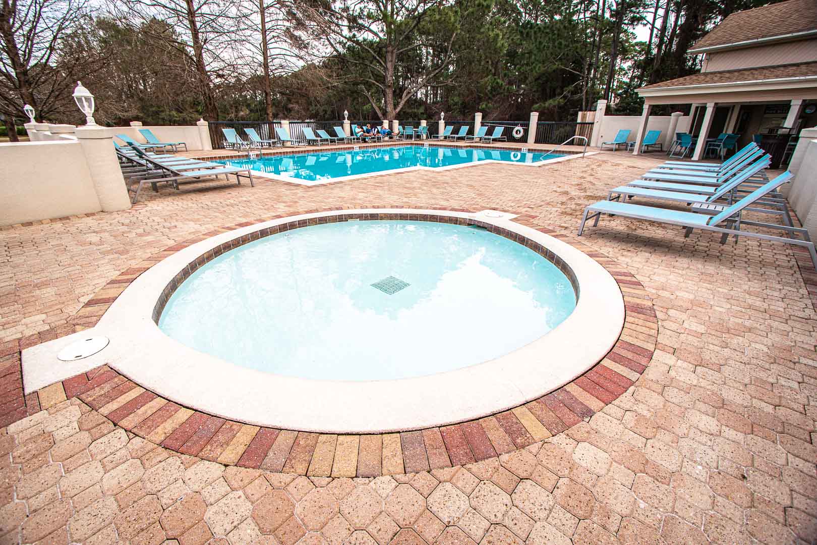 An outdoor swimming pool with a kid pool at VRI's Bay Club of Sandestin in Florida.